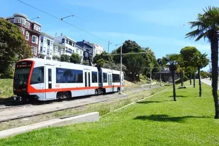 MUNI passenger train runs along A track in San Francisco.